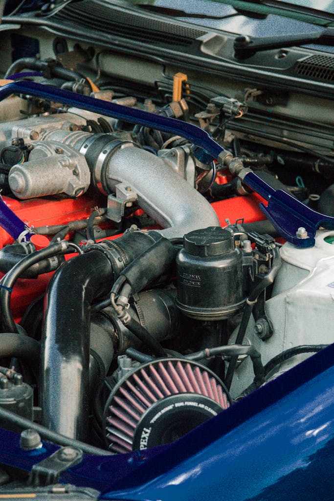Imagen actual: Detailed view of car engine components with focus on parts and machinery.