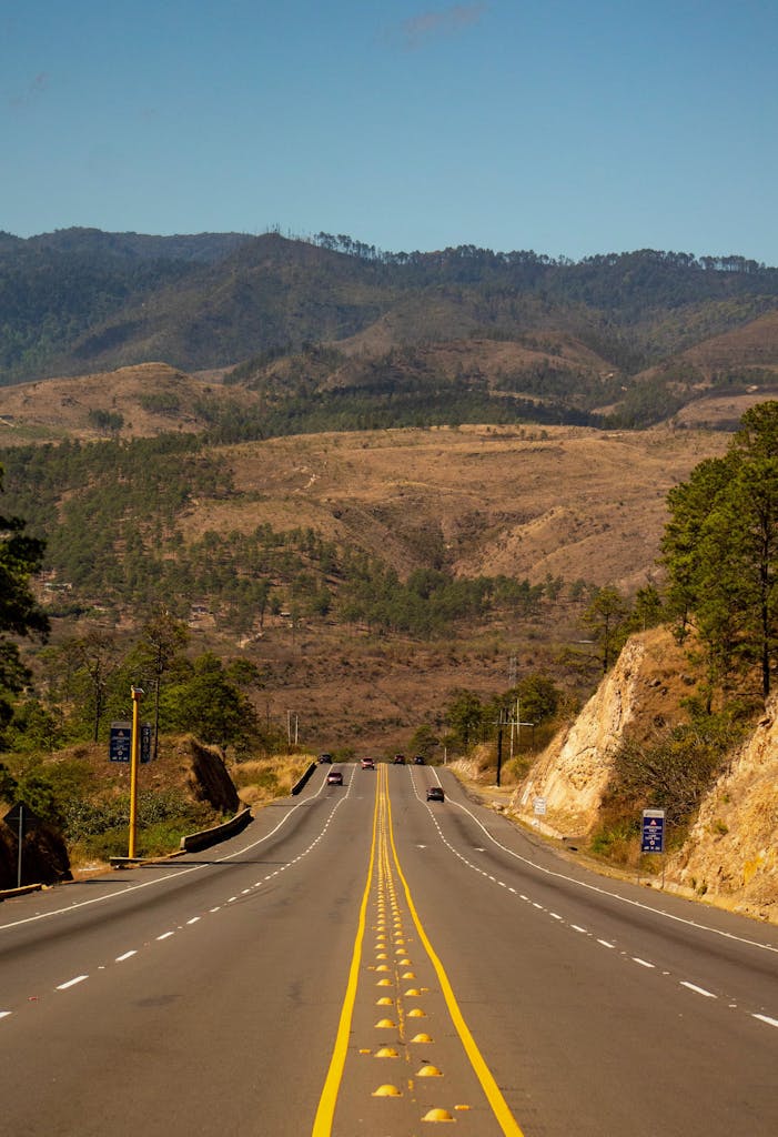 Imagen actual: A scenic highway stretching through the hilly landscape of Amarateca, Honduras.