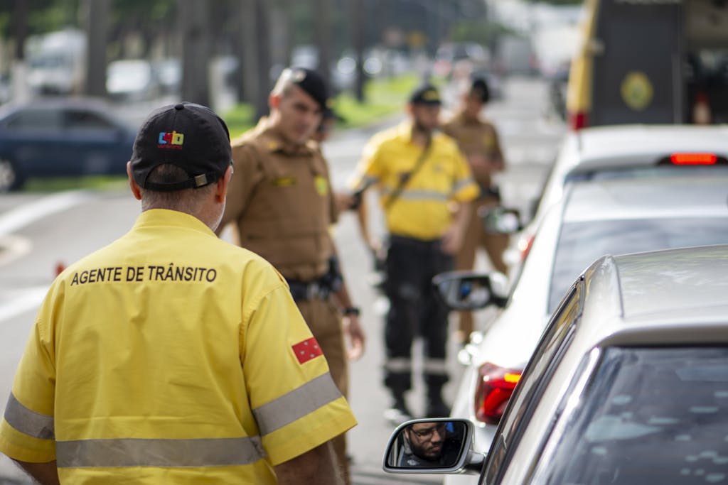 Imagen actual: Traffic agent in bright uniform managing vehicles on a busy Londrina street.