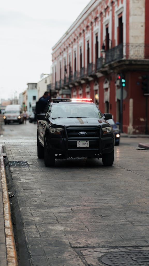 Imagen actual: A police car on a historic city street with vintage architecture and urban ambiance.